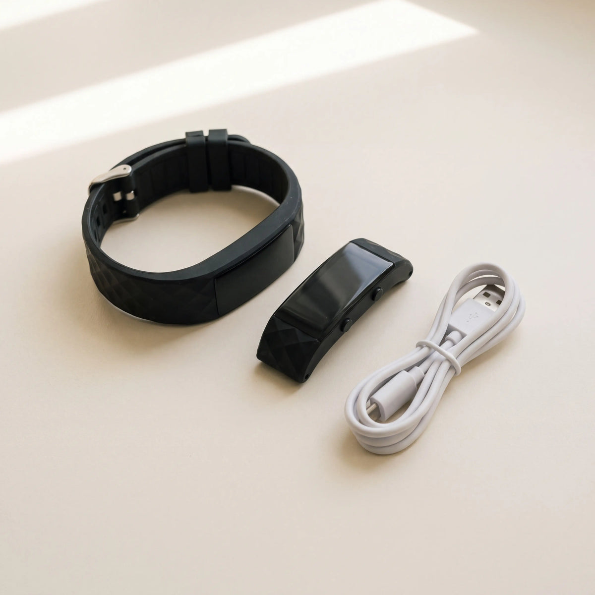 Band module removed from its strap beside a USB cable